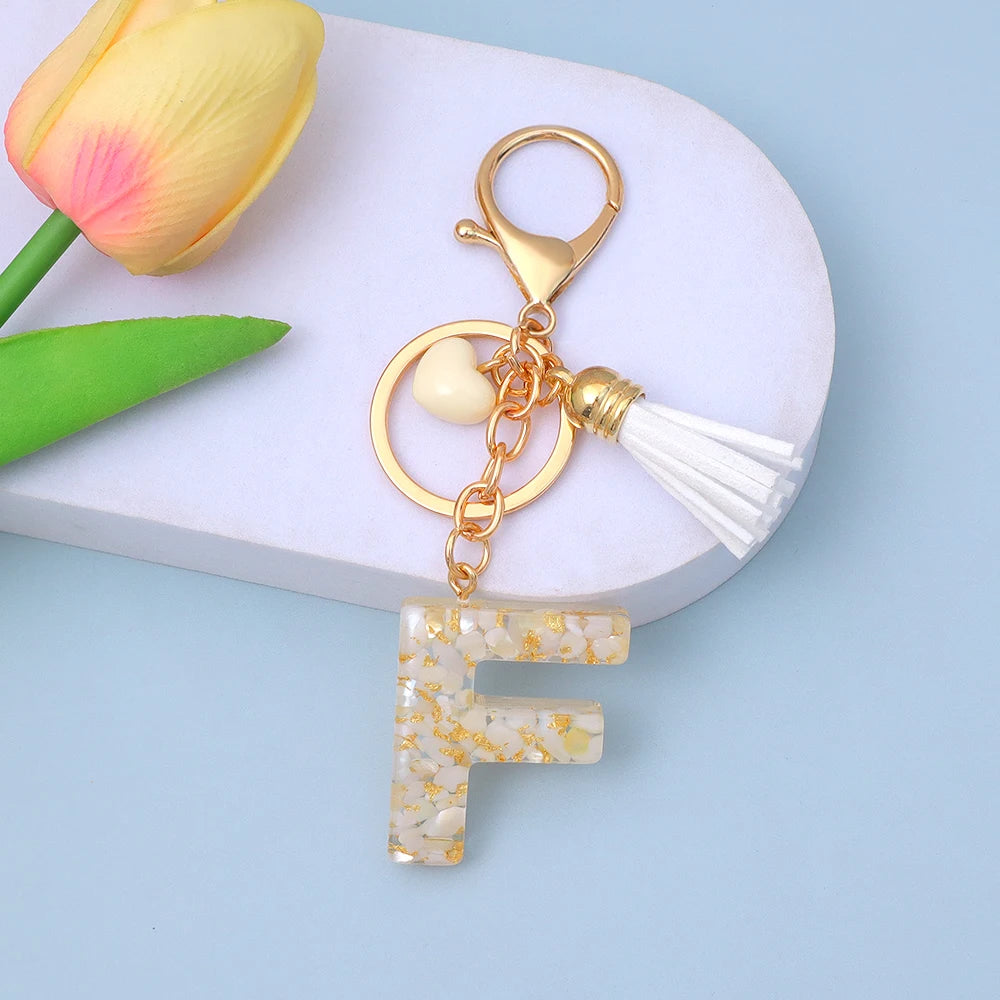 ميدالية مفاتيح بالحروف الـ 26 من الراتنج، دلاية عصرية بلون كريمي بقلب وشرابة، حلقة مفاتيح بحروف من A إلى Z للنساء، زينة للحقيبة وهدية حفلات